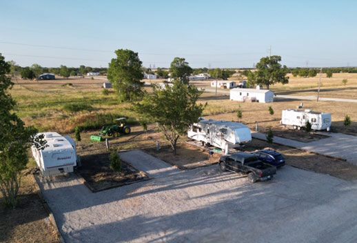 Aerial view of RV sites, mature trees and open pasture at Stoney Acres RV Park, Ponder, Texas