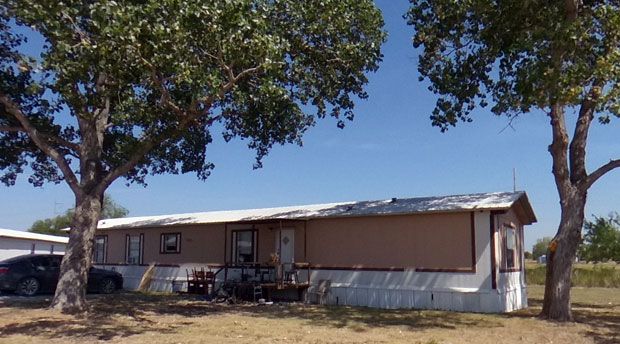 Mobile home rental shaded by mature trees at Stoney Acres RV Park near Denton, TX